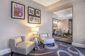 Relax in a spacious lobby with a seating area, artwork, and carpeted floor.