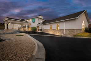 A hotel with a covered entrance, stone facade, and a sign indicating it is a Quality Inn.