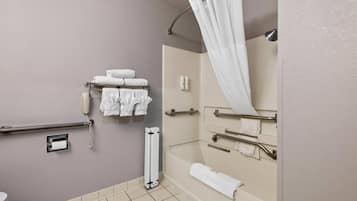 A bathroom with a toilet, a shower with a curtain, a bathtub, and a towel rack with towels.