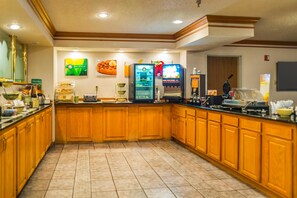 A kitchen with wooden cabinets, a refrigerator, a microwave, and a coffee machine.