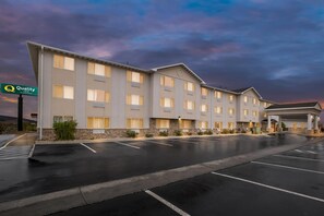 A hotel with a modern design, featuring a parking lot and a sign indicating it is a Quality Inn. - Quality Inn near Monument Health Rapid City Hospital (Rapid City)