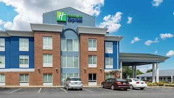 A Holiday Inn Express building with a brick facade, large windows, and a covered parking area.