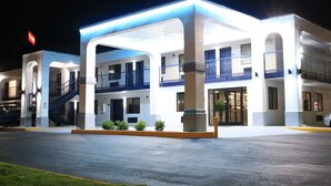 A hotel with a covered entrance, multiple balconies, and a visible staircase. - Econo Lodge Inn & Suites Southeast (La Vergne)