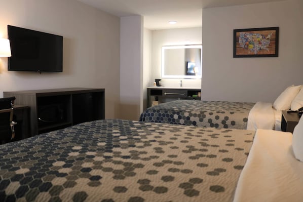 A hotel room with two beds, a TV, a mirror, and a map on the wall. - Econo Lodge Inn & Suites Southeast (La Vergne)