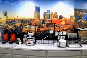 A cityscape view with a coffee station featuring coffee dispensers, bowls, and plates. - Econo Lodge Inn & Suites Southeast (La Vergne)