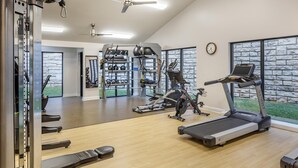 Un gimnasio con cintas de correr, elípticas y equipamiento de levantamiento de pesas.