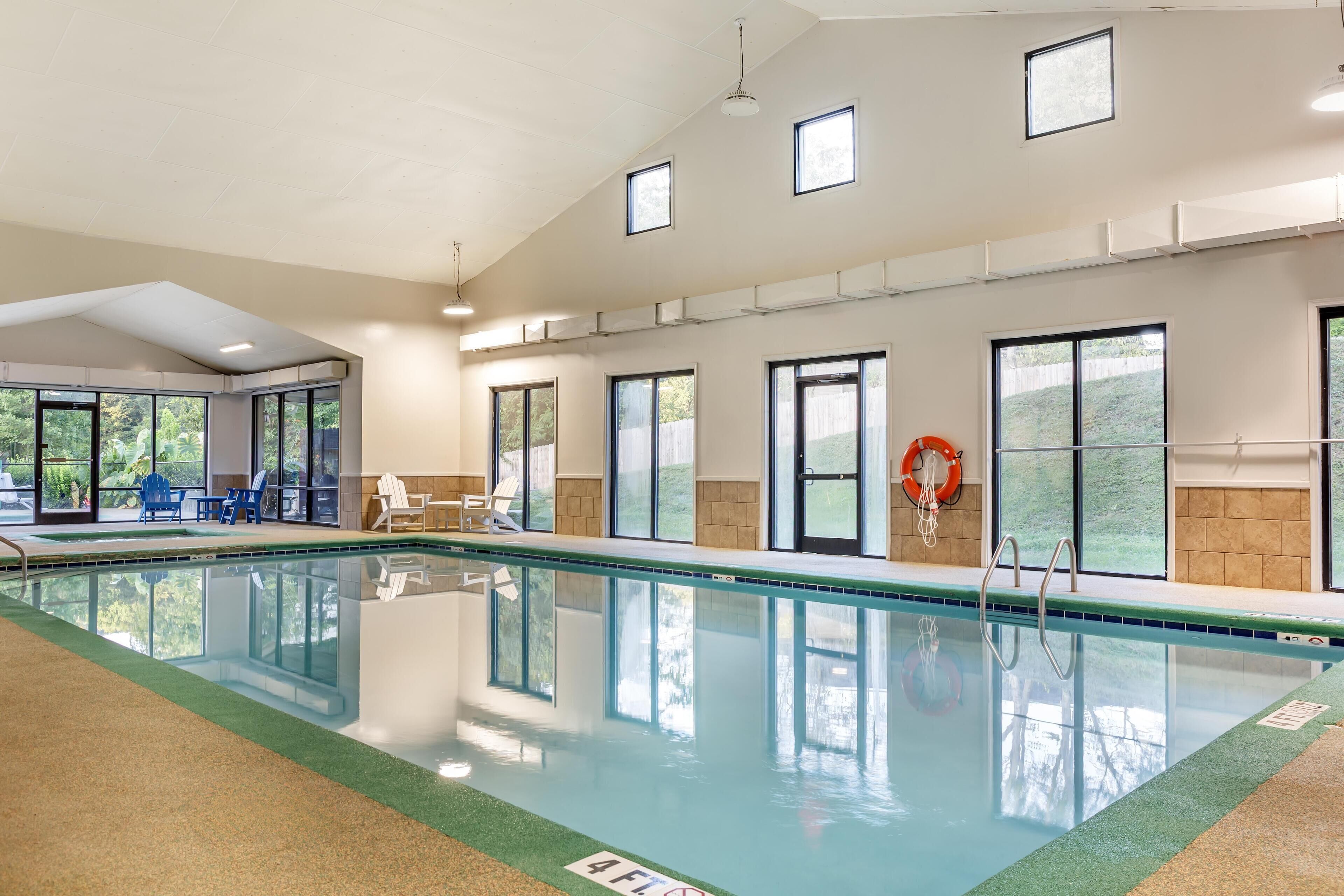 An indoor swimming pool with clear glass walls, a lifebuoy, and a 4FL sign.