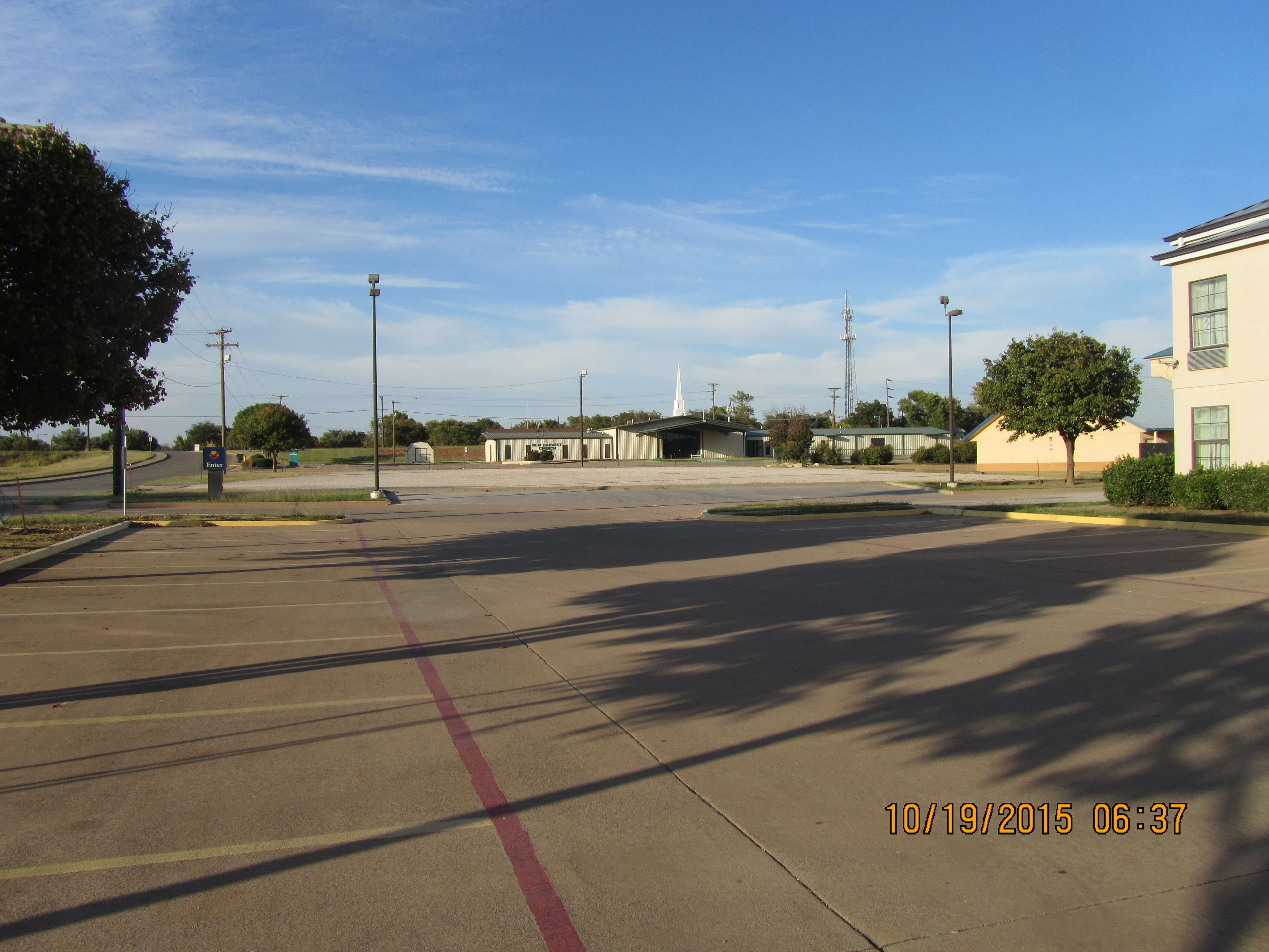 A parking lot with a building in the background.