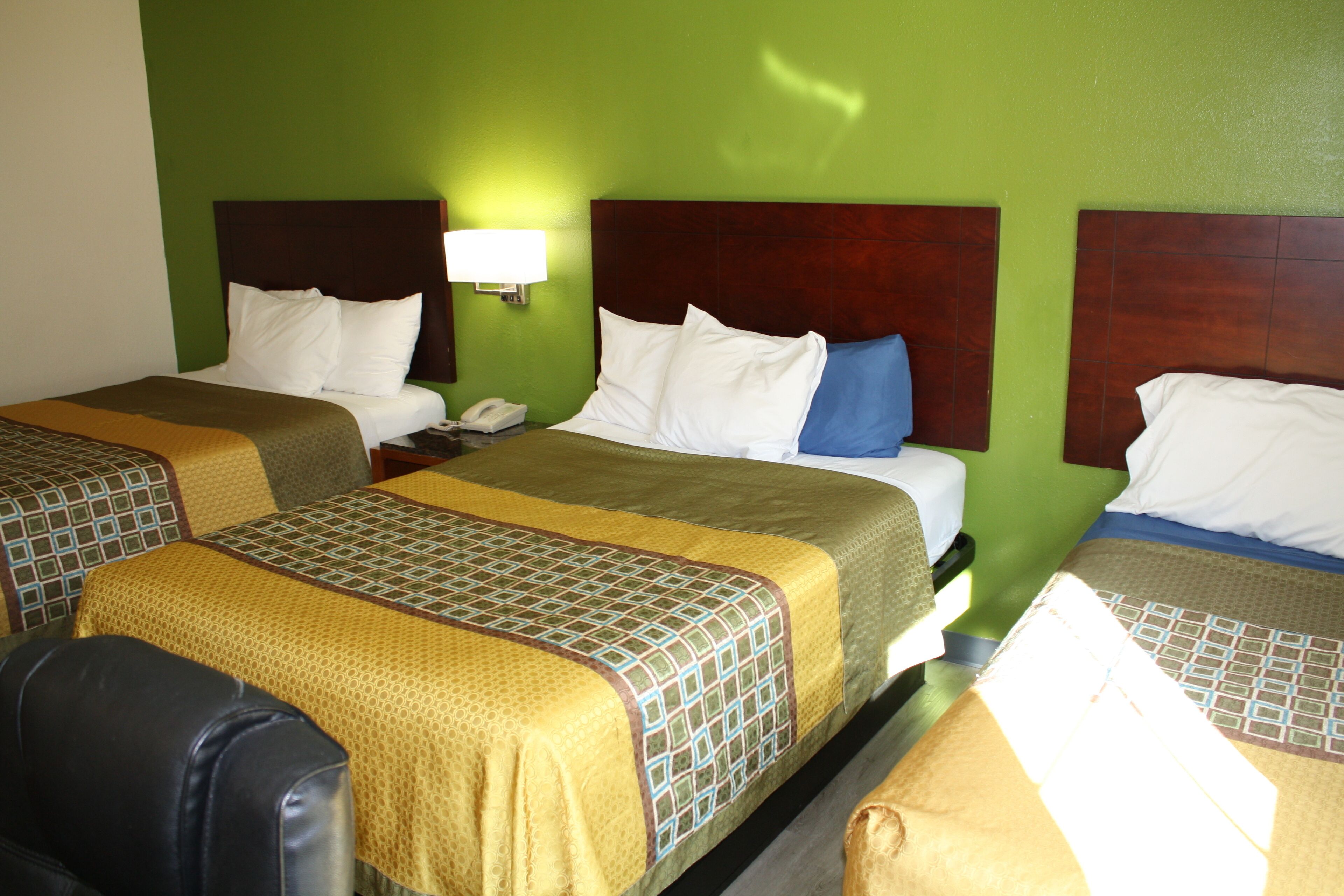 Habitación de hotel con dos camas, cada una con cabecera, mesita de noche y lámpara.