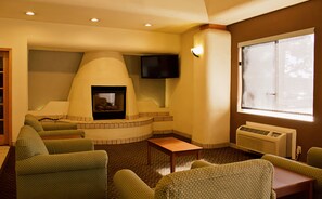 Cozy living room with a fireplace, comfortable seating, and a flat-screen TV.