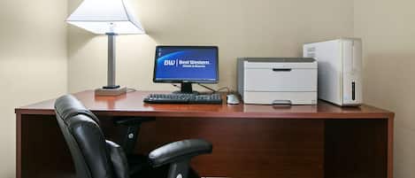 A hotel desk with a computer, monitor, keyboard, mouse, and printer.