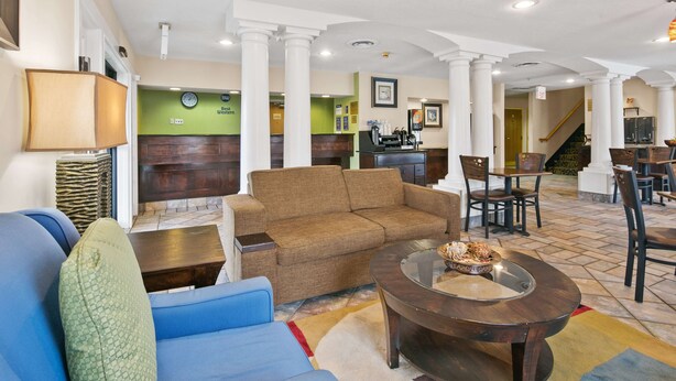 A spacious lobby with a brown sofa, blue armchair, and a round coffee table with a decorative bowl. - Best Western San Marcos (San Marcos)
