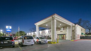 A well-lit gas station with multiple cars parked, a clear sky, and a building with a covered area. - Best Western San Marcos (San Marcos)