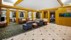 A spacious lobby with a high ceiling, yellow accents, and a large aquarium. - Days Inn & Suites by Wyndham Corpus Christi Central (Corpus Christi)