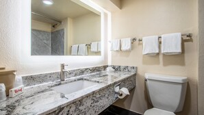 A bathroom with a marble sink, a toilet, and a mirror. - Red Roof Inn El Paso West (El Paso)