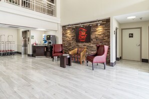 A hotel lobby with a reception desk, a water dispenser, and seating areas. - Red Roof Inn El Paso West (El Paso)