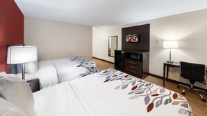 A hotel room with two beds, a desk, a chair, a TV, and a lamp. - Red Roof Inn El Paso West (El Paso)