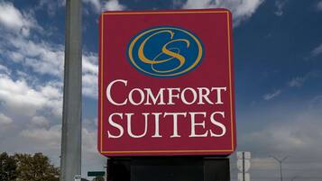 A sign for 'Comfort Suites' with a logo and text.