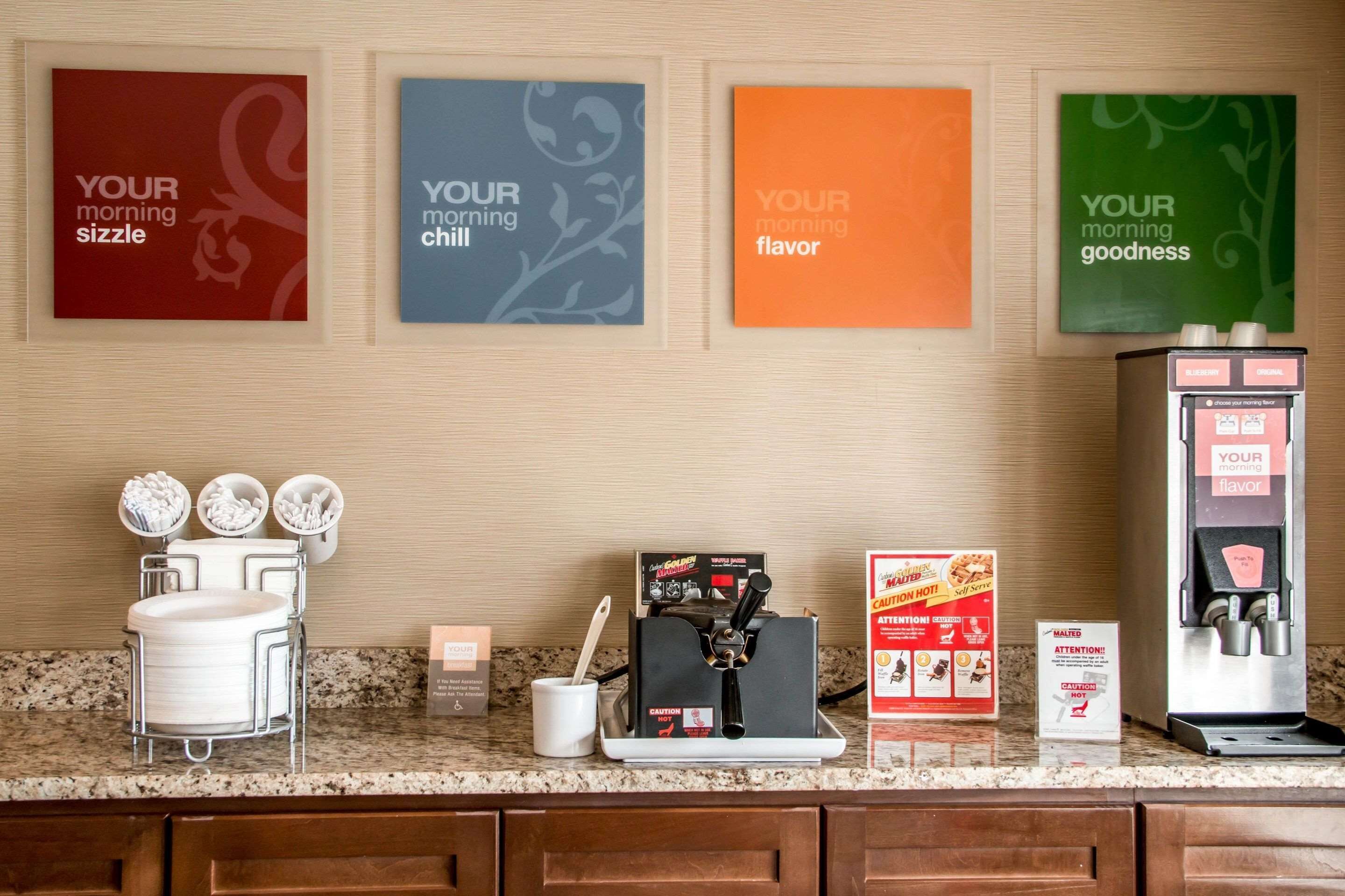 Un coin café équipé d’une machine à café, de tasses et d’un panneau indiquant : « Votre café du matin. »