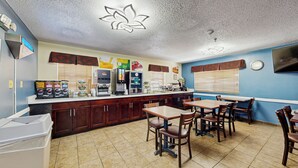 A cafe with a counter, seating, and a clock on the wall.