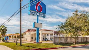 Un motel con un cartel llamativo con el número '6' y un anuncio que dice 'INTERNET WI-FI GRATIS'.