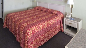 A hotel room with a large bed, two bedside tables with lamps, and two framed pictures on the wall. - Rodeway Inn San Juan (San Juan)