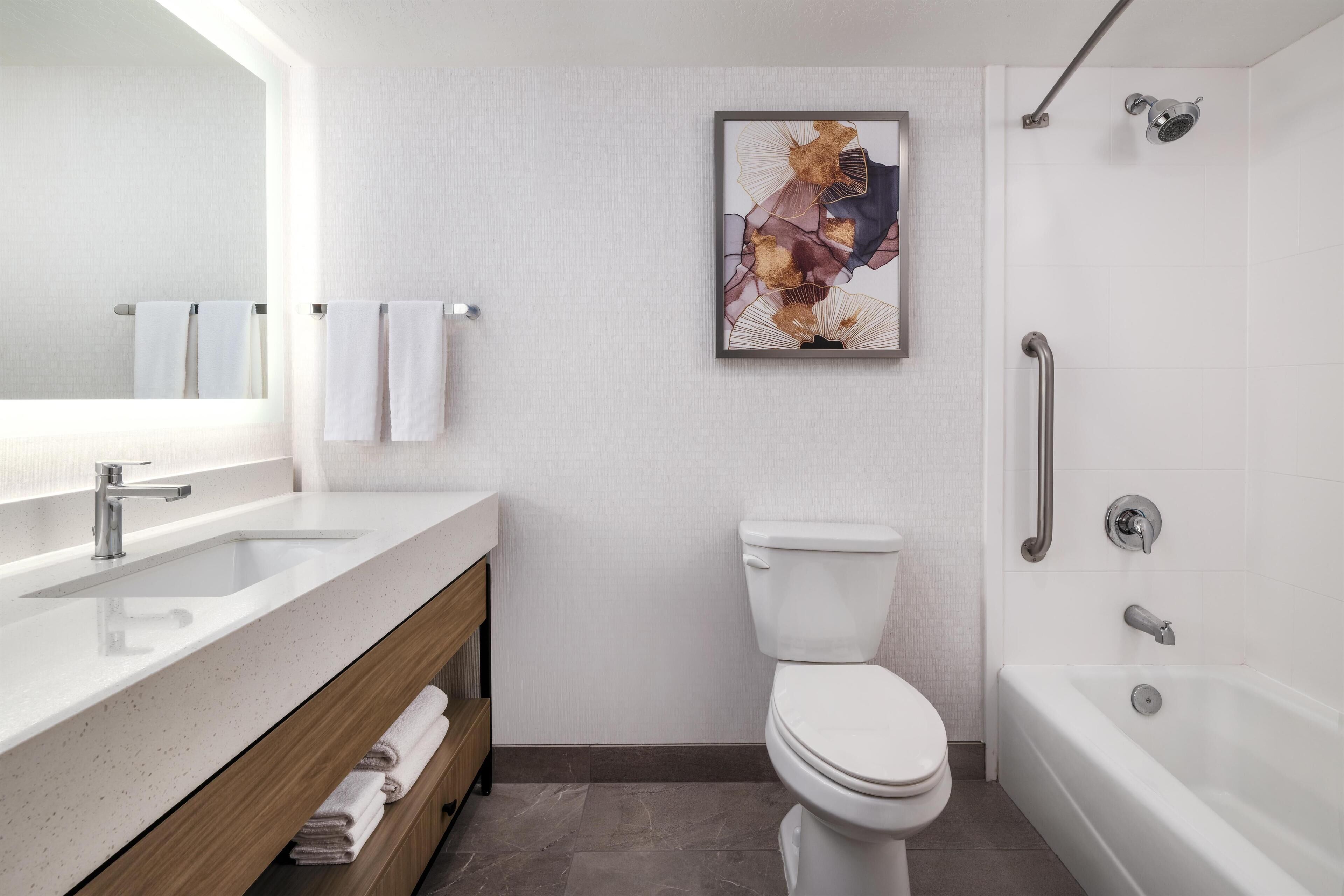 Een moderne badkamer met een wastafel, toilet en bad.