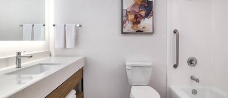Een moderne badkamer met een wastafel, toilet en bad.