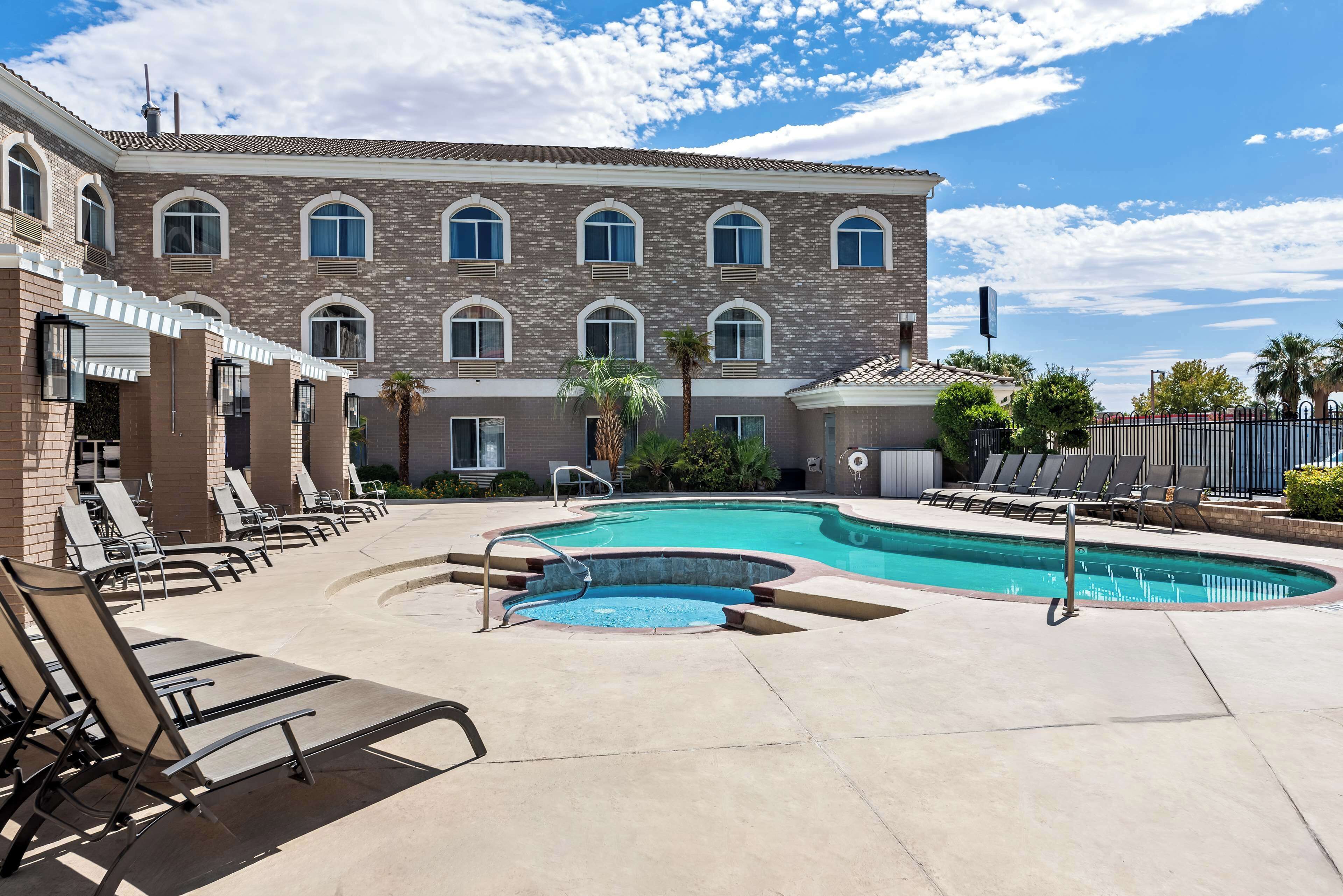 Un hôtel doté d’une piscine, de chaises longues et d’une façade en briques.