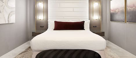 A modern bedroom with a large bed, two bedside tables, a nightstand, a decorative wall piece, and a framed picture on the wall.