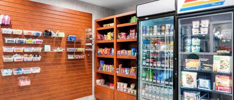A store interior with shelves stocked with snacks, beverages, and household items.