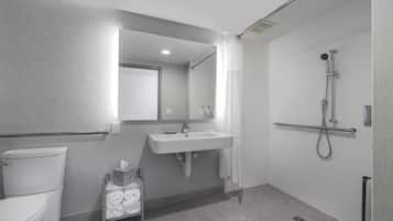 A modern bathroom with a toilet, sink, and shower.