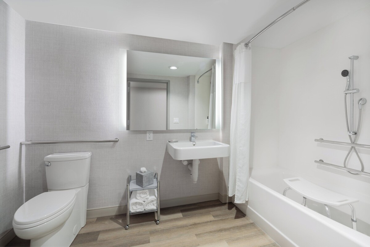 A modern bathroom with a toilet, sink, and bathtub.