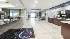 Un moderno vestíbulo de hotel con mostrador de recepción, zona de estar y un amplio ventanal.
