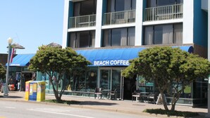 A multi-story building with a blue awning labeled "BEACH COFFEE". - Days Inn by Wyndham Virginia Beach At The Beach (Virginia Beach)