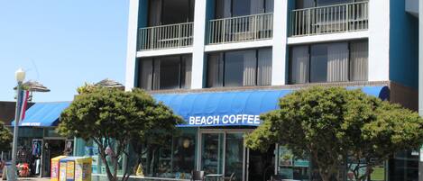 A multi-story building with a blue awning labeled "BEACH COFFEE".