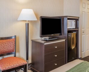 A hotel room with a television, microwave, minibar, and a chair. - Comfort Inn On the Bay (Port Orchard)