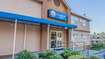 Een Comfort Inn hotel met een blauw luifel, een ruime ingang en een heldere lucht.