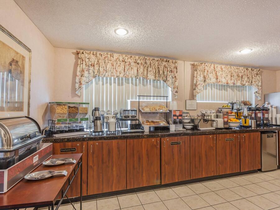 Ein Selbstbedienungs-Frühstücksbuffet mit einer Kaffeemaschine, einem Toaster und einer Auswahl an Speisen.