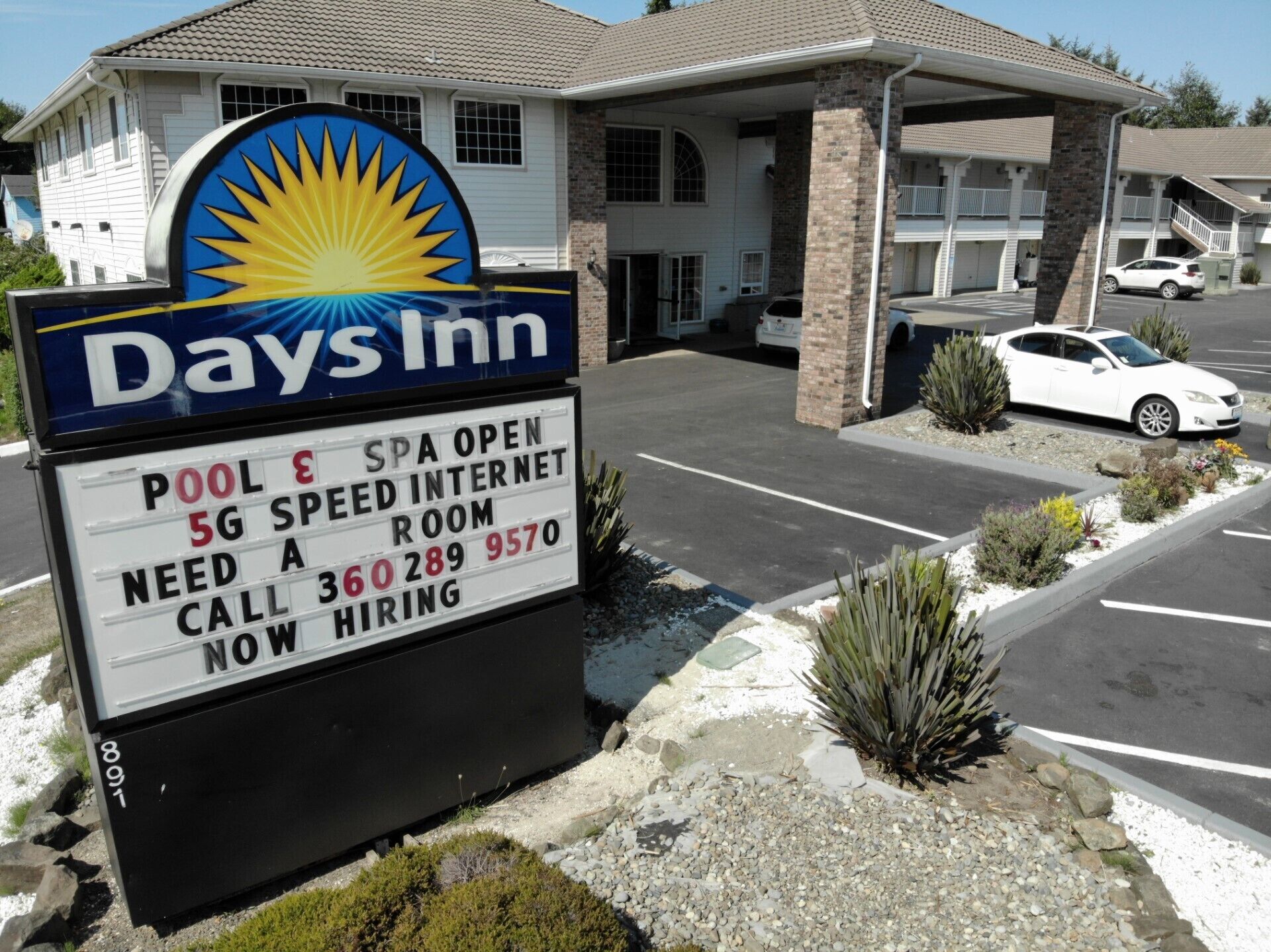 A Days Inn signboard with amenities like pool, spa, 5G internet, and a room for hire.