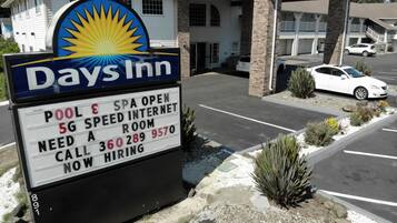 A Days Inn signboard with amenities like pool, spa, 5G internet, and a room for hire.
