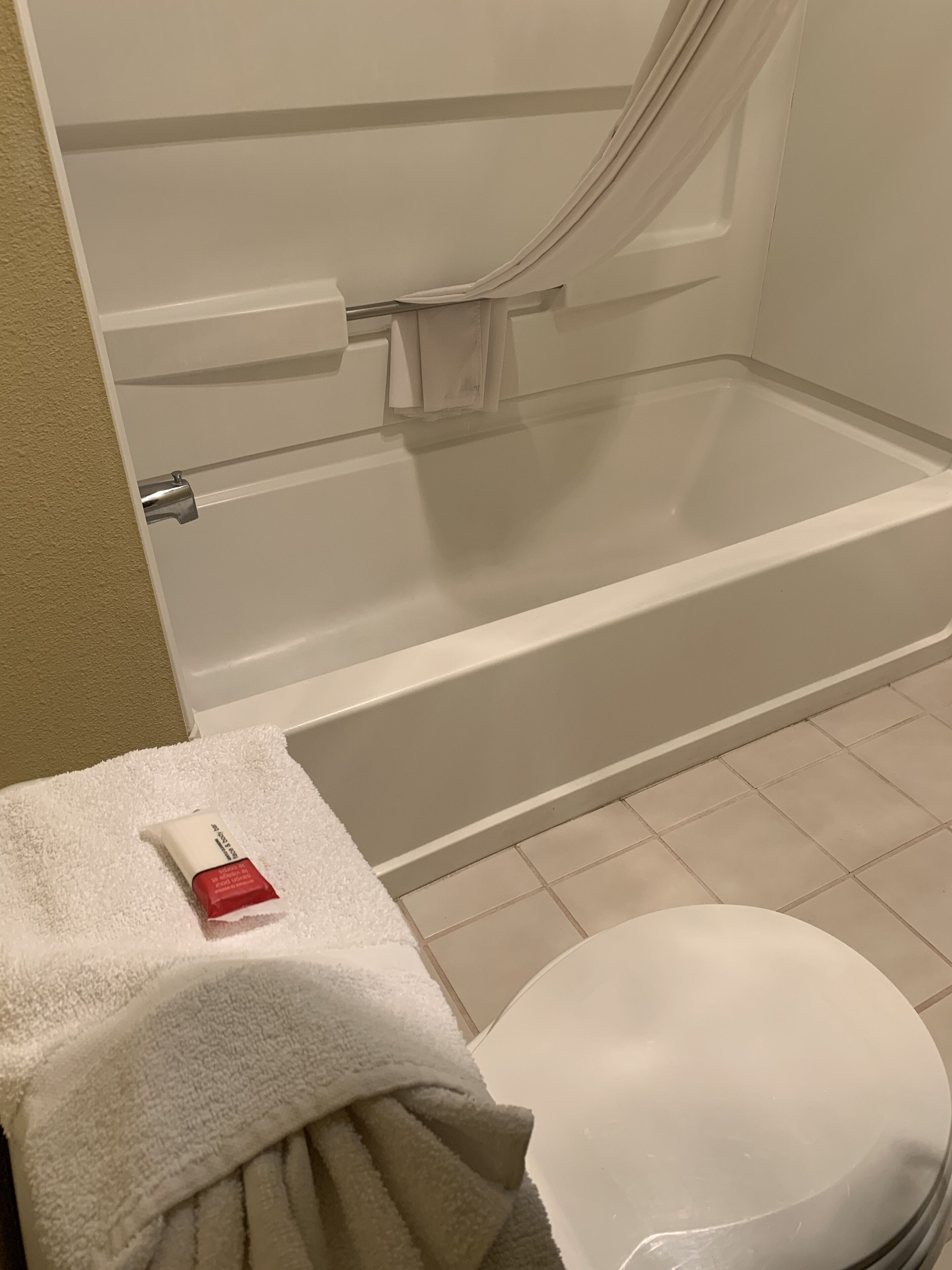 Ein Badezimmer mit einer Badewanne, einer Toilette und einem Handtuch auf dem Boden.