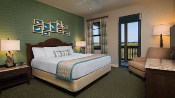 A hotel room with a large bed, two bedside tables with lamps, a chair, a desk, and a balcony with a view.