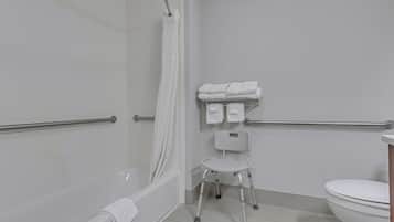 A bathroom with a shower, a toilet, and a wheelchair-accessible bench.