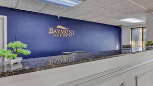 A reception desk with a blue wall and a sign for Baymont Inn & Suites. - Baymont by Wyndham N Myrtle Beach/Park & Sports Complex Area (North Myrtle Beach)