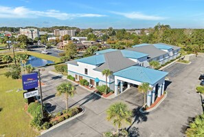 Un hôtel avec un toit bleu, un parking et une enseigne indiquant qu’il s’agit d’un établissement Baymont by Wyndham.