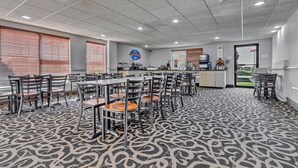 A spacious indoor area with multiple tables and chairs, a patterned carpet, and a ceiling with recessed lighting. - Baymont by Wyndham N Myrtle Beach/Park & Sports Complex Area (North Myrtle Beach)