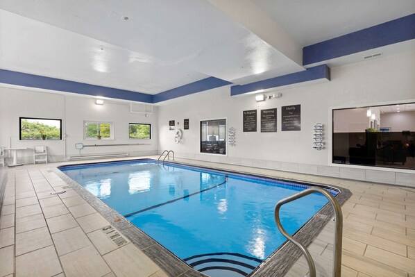 Una piscina interior con agua cristalina azul, suelo de baldosas y una decoración azul y blanca.