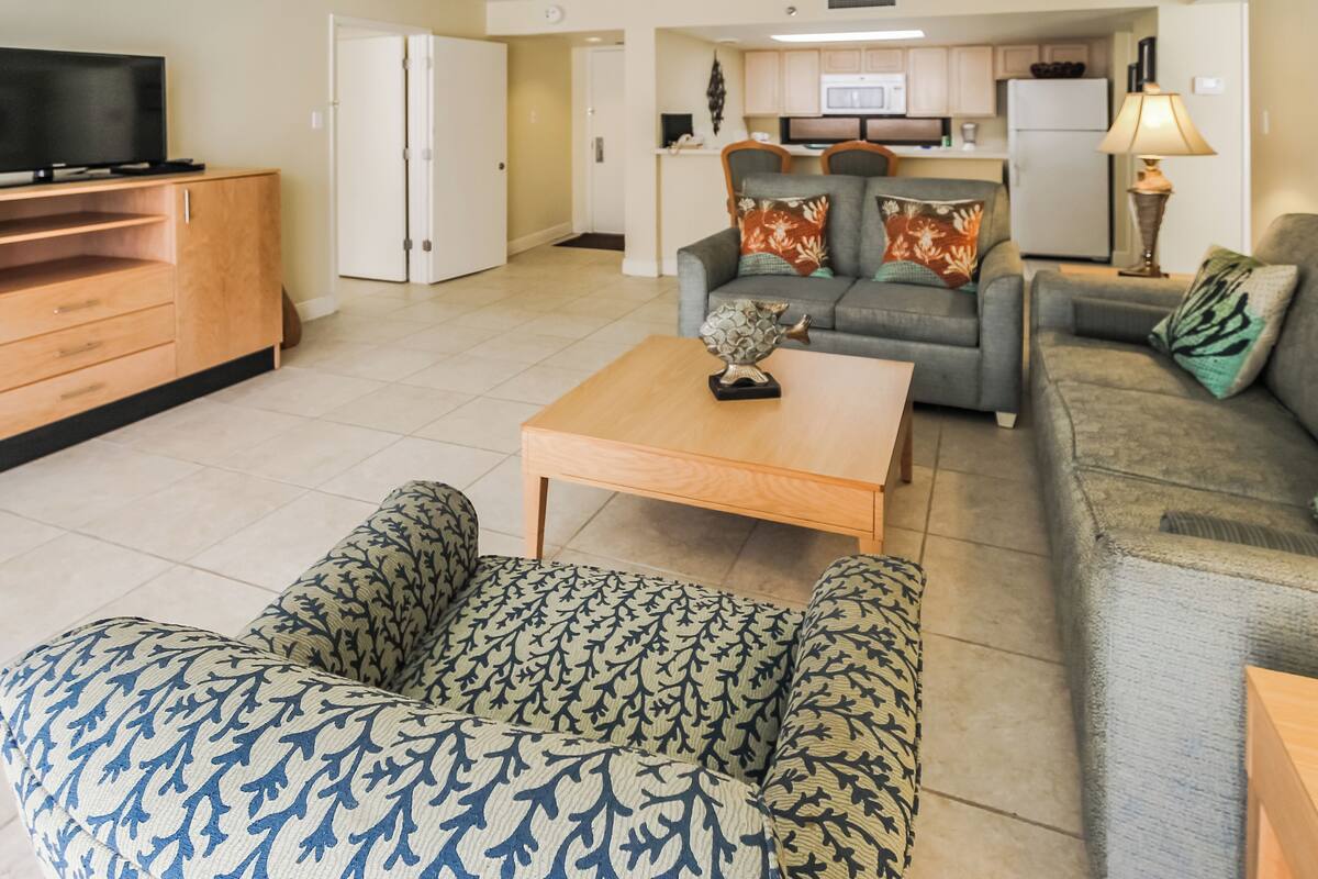 A modern living room with a sofa, a coffee table, and a television.
