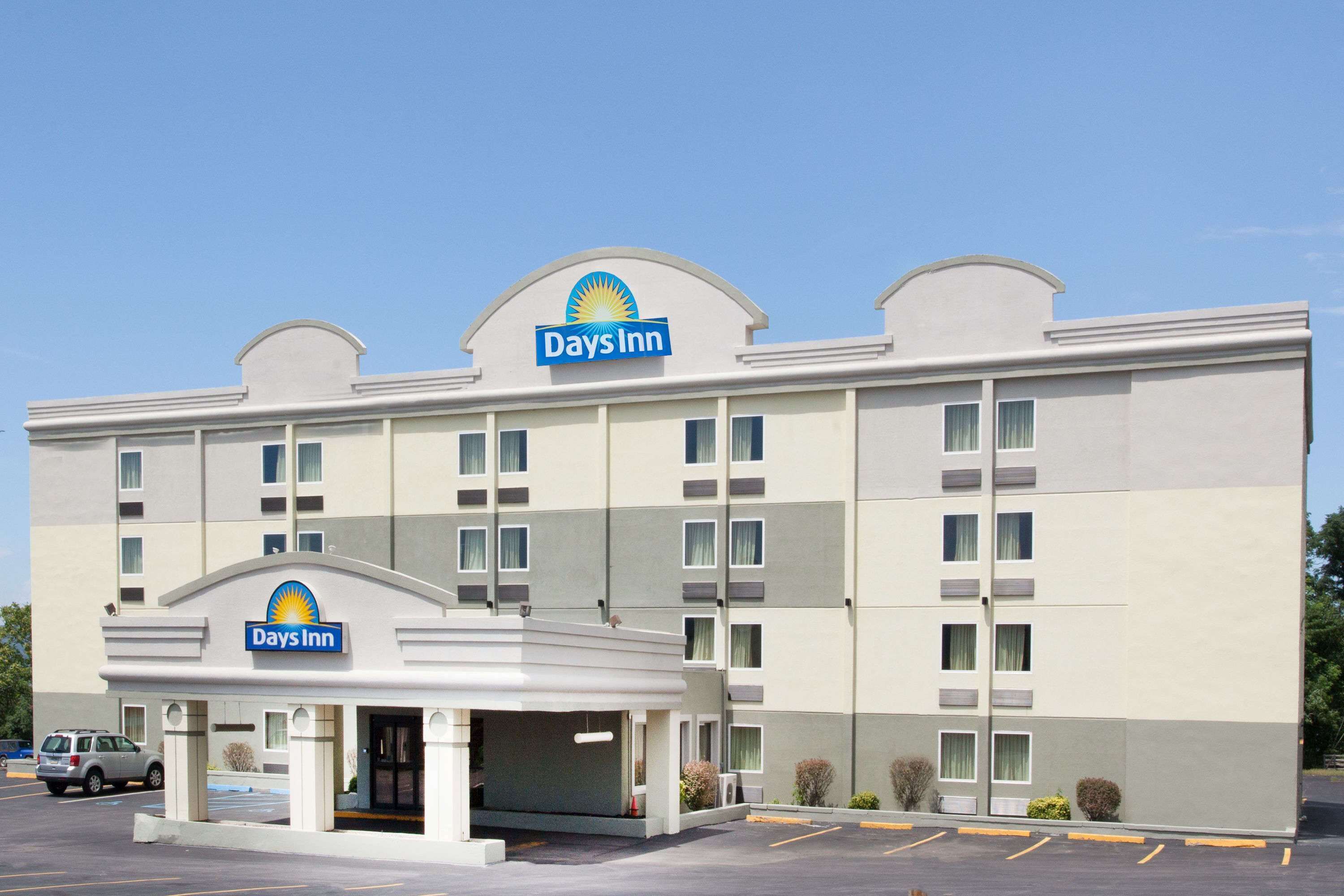 A Days Inn hotel with a flat facade, multiple windows, and a parking lot.